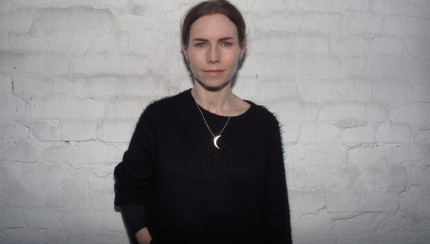 Nina Persson vor weißer Mauerwand
