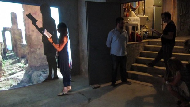 castrato: cuts from a scene, 2012, impromptu reading from via grimaldi written in residence during a 24hour performance (the 2nd piece in the pedestrian series). the main text is read by a male reader situated in front of the stairs to the installation’s “staging area,” including the photo installation staging, while the footnotes are read by a female reader in the guise of a greek chorus in front of the video projection, scene for a backdrop (all places are temporary), 2013 a non-static still video shot at the valley of the temples. installation view: bocs, catania, sicily (2012)