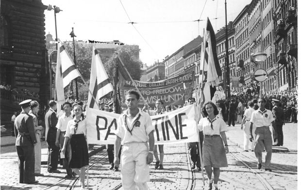 Eine Delegation, bestehend aus jungen jüdischen und arabischen Kommunisten aus Palästina, die im Juli 1947 an einem Aufmarsch bei den Weltfestspielen der Jugend und Studenten in Prag teilnahm. Auf ihrem Banner ist zu lesen: „Die Straße zur Freiheit – ein jüdisch-arabisches Solidaritätsprojekt". Foto: Jakob Kösten